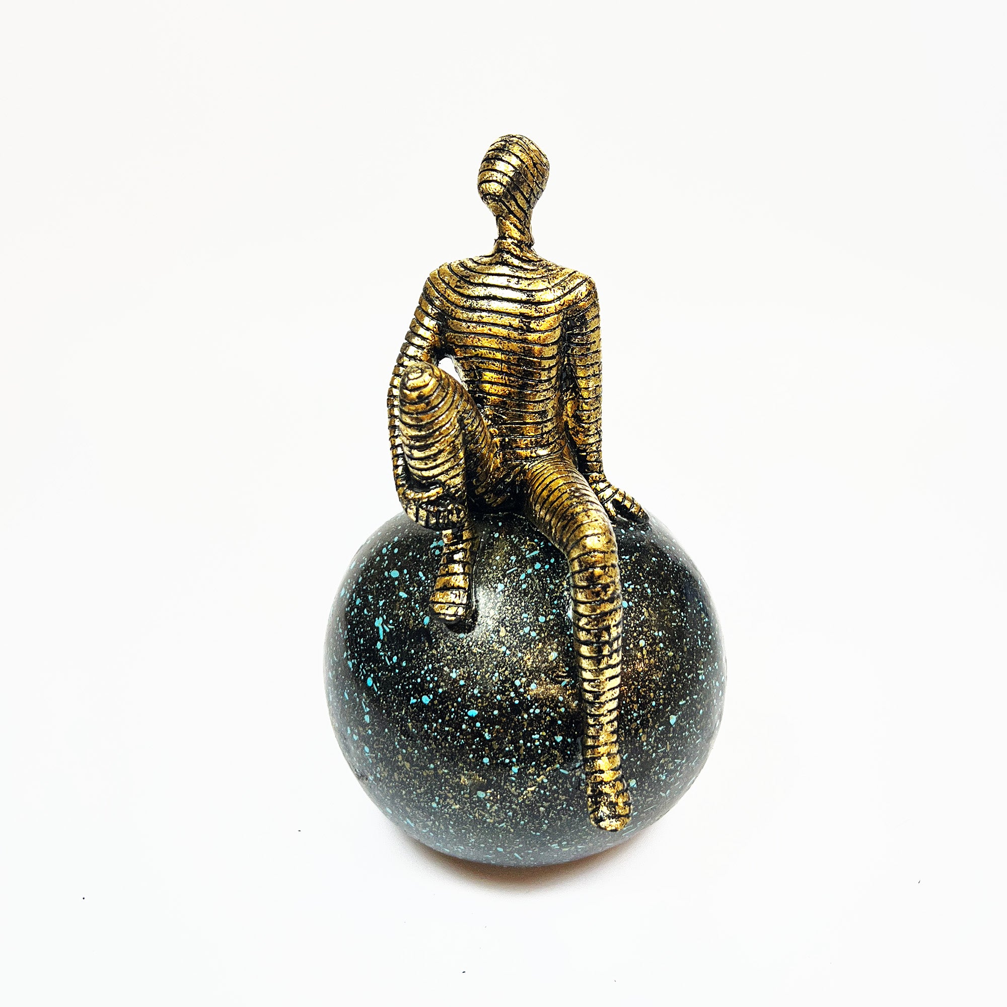 Golden Abstract Figurine Sitting on Globe
