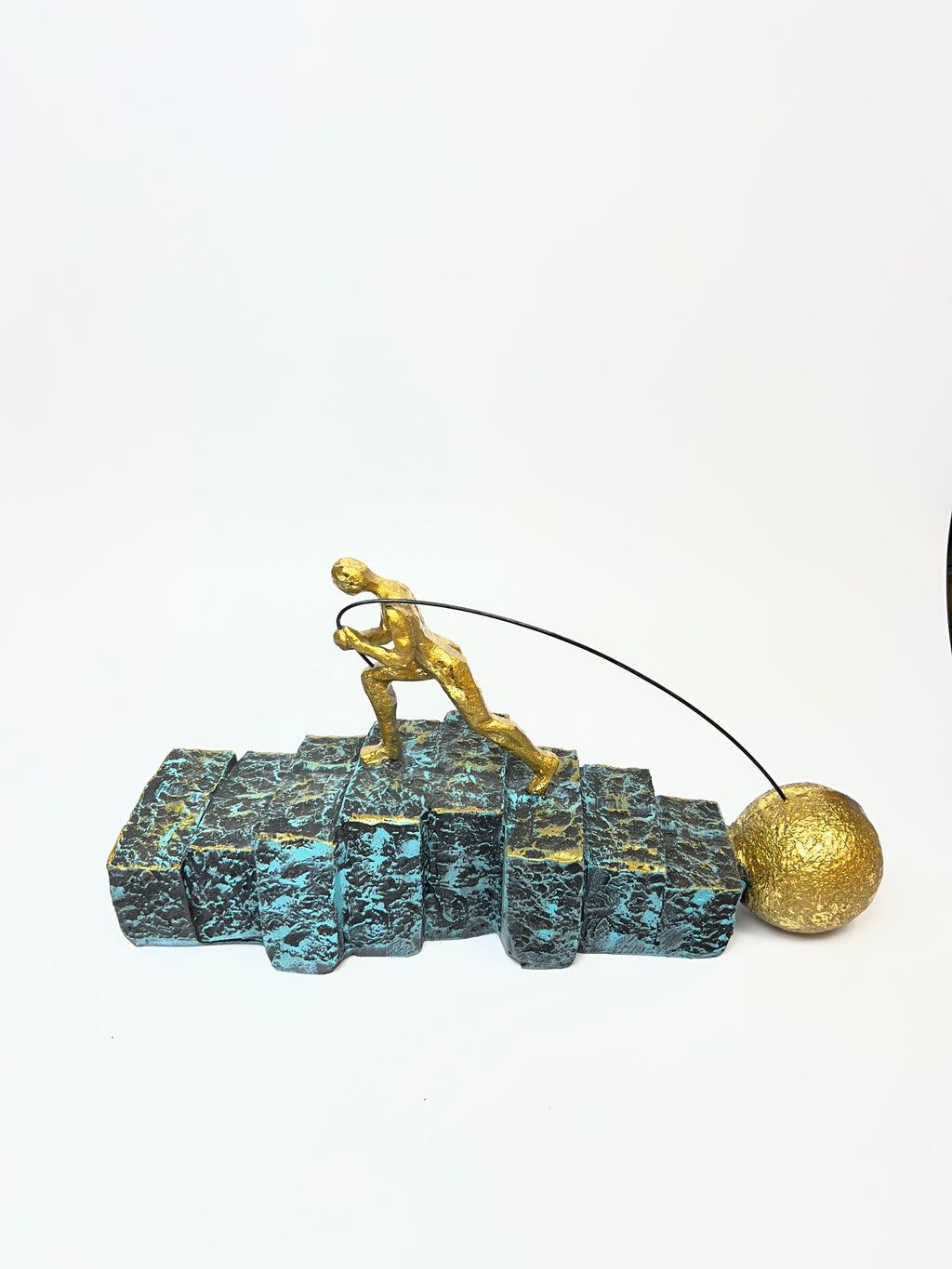 Golden Figurine Pulling Ball on Stairs