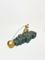 Golden Figurine Pulling Ball on Stairs
